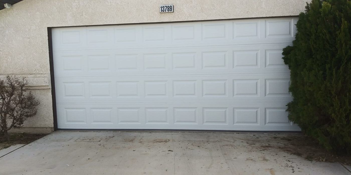 The same garage opening with a new white sectional steel door fitted