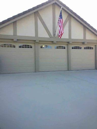 Three-car cream steel garage doors on a Southwest Riverside County home