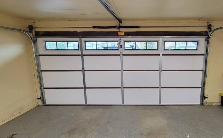 Garage door interior showing torsion spring, tracks and opener rail