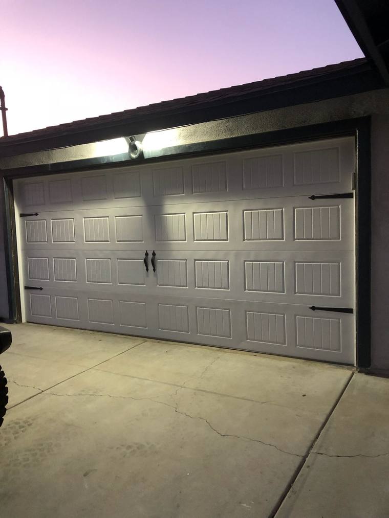 White carriage-style steel door with strap hardware