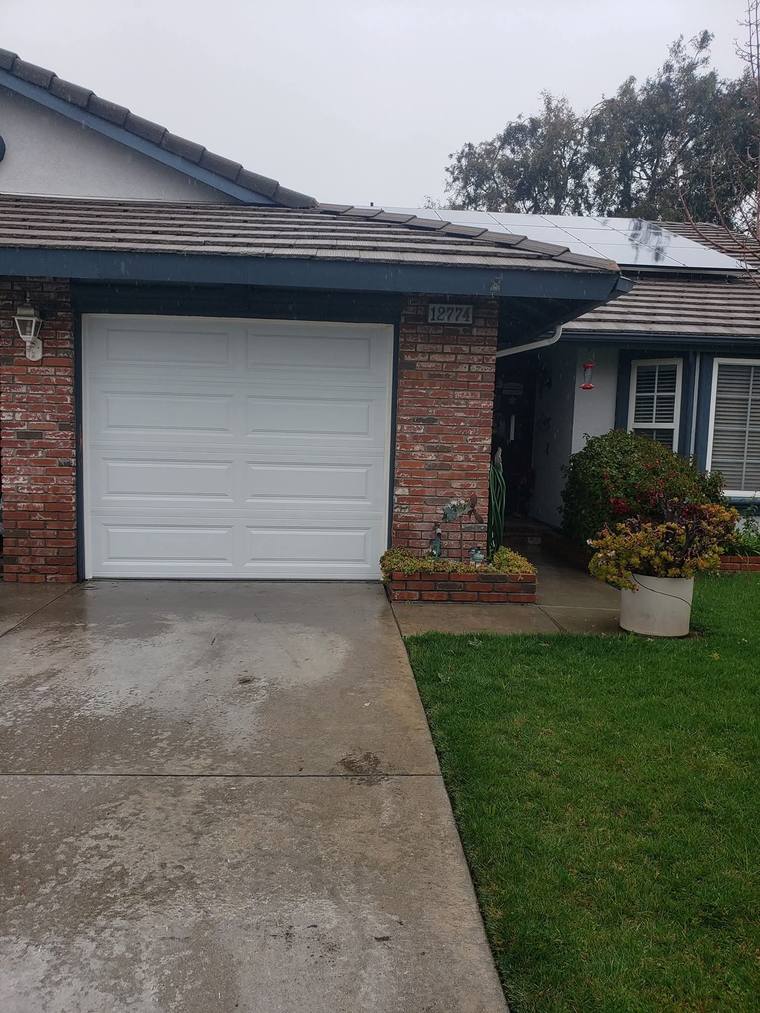 White long-panel steel garage door on a brick-fronted Riverside home
