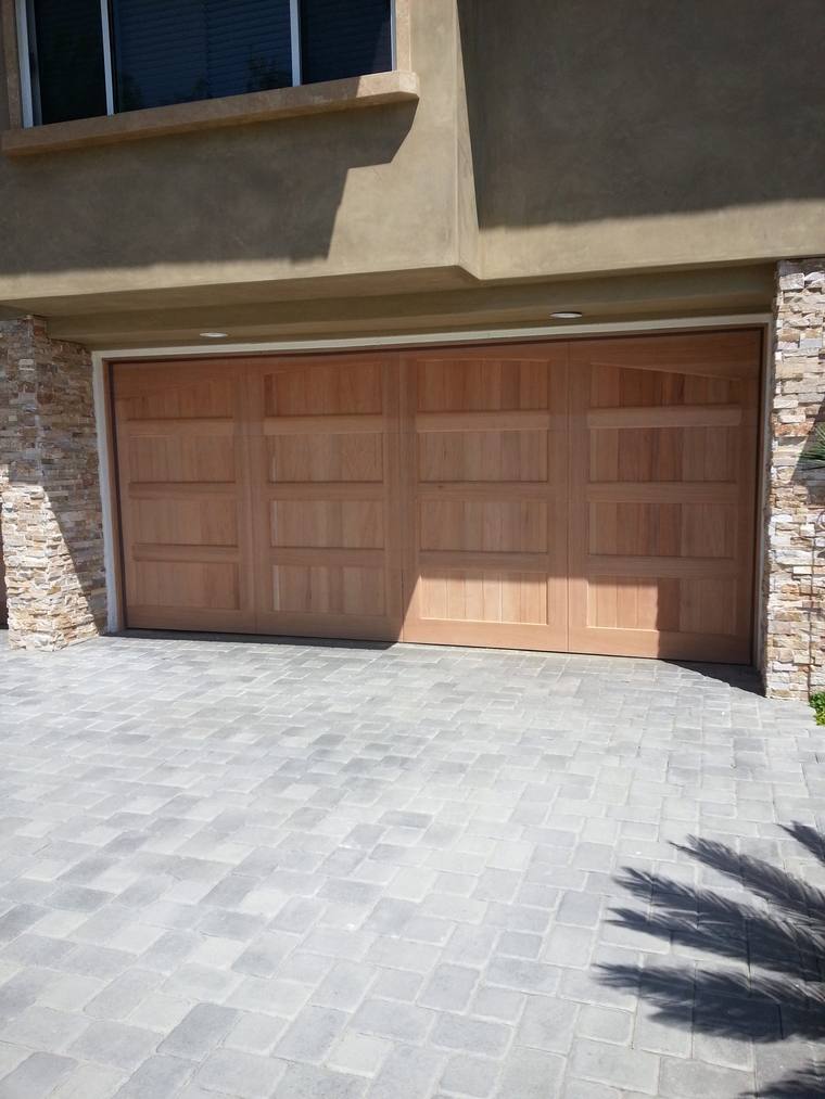 Real cedar carriage-style garage door on a stone-fronted home