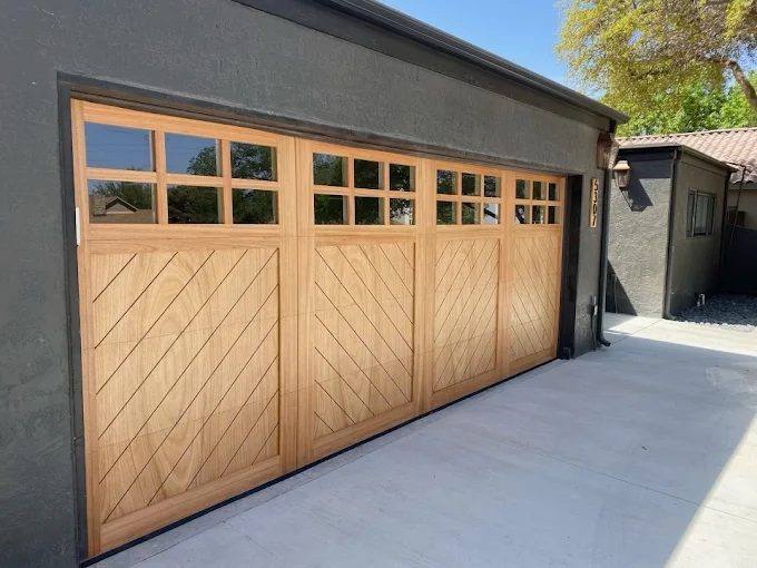 Custom natural oak carriage garage door with chevron panels and glazed top row