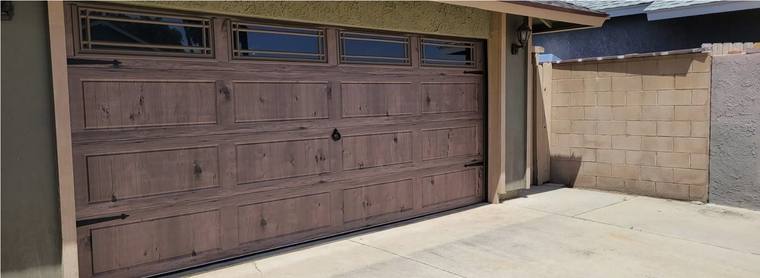 Driftwood-finish wood-grain steel garage door with decorative glazing