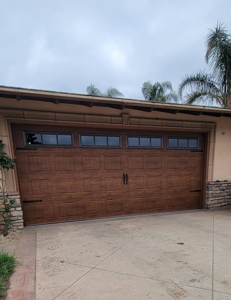 Walnut wood-grain steel garage door with decorative window row, Riverside County
